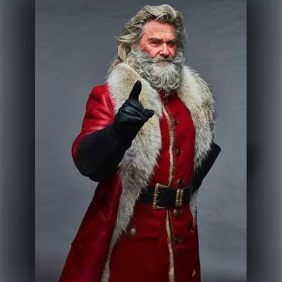 Older man dressed as Santa Claus in a luxurious red leather coat with fur trim, pointing forward.
