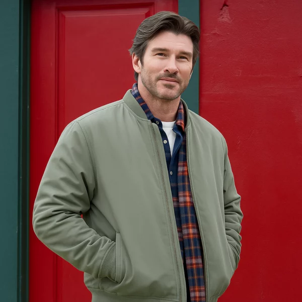Man wearing a stylish green cotton jacket over a plaid shirt standing in front of a red door